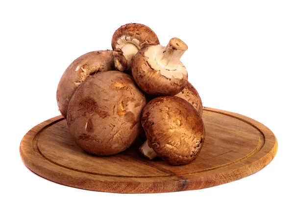 Champignon grande real en una tabla redonda de madera que corta. en un wh —  Fotos de Stock