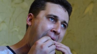 Bir iştah ile sevimli genç aç beyaz adam lezzetli ve sulu sandviç yiyor, dikkatle yakın çekim, yavaş hareket çiğneme