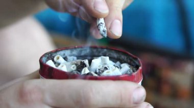 Sigara adam bir küllük sigara Butts dolu bir sigara popo koyar, eller yakın çekim