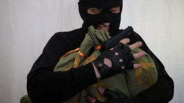 bir sırıtma ile Balaclava Genç beyaz hırsız ve zevk para çalıntı çanta ile kucaklayan yakın çekim