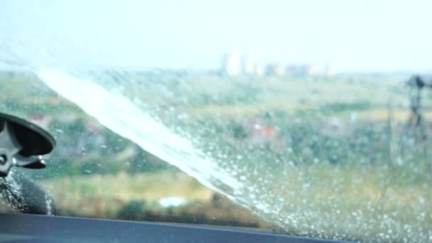 노즐이 유리에 와이퍼가 표면의 먼지와 먼지를 깨끗하게 청소하고 밖에서 클로즈업 — 비디오