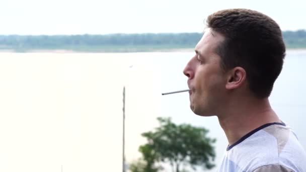 Young Handsome Caucasian Man Smokes Cigarette Background River Close — Stock Video