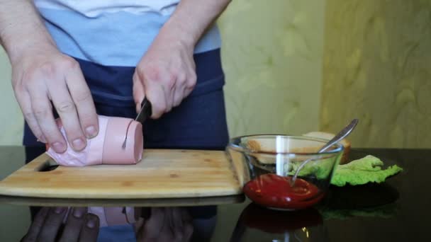 Молодий Чоловік Ріже Шматочки Ковбаси Обробній Дошці Виготовлення Бутерброду Поруч — стокове відео