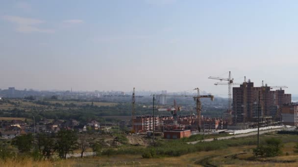 Mehrere Turmdrehkräne Bauen Ein Mehrstöckiges Gebäude Und Bewegen Fracht Fernplan — Stockvideo