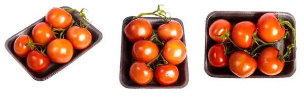 Ripe red tomatoes in a dark plastic tray. on a white set — Stock Photo, Image
