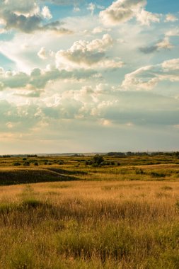 Akşam bozkırlarında mavi gökyüzü ve bulutlarla