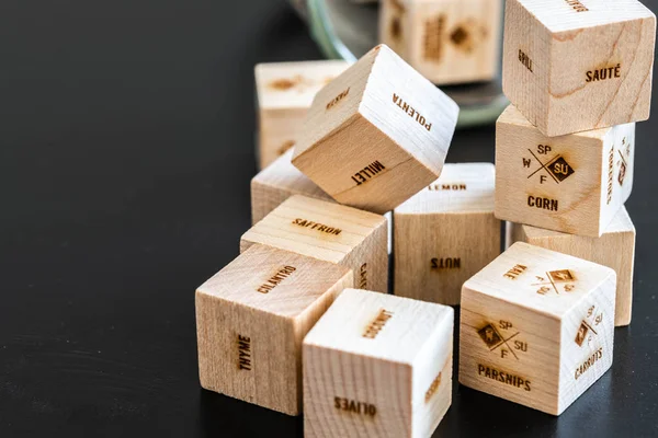 Lots of wooden cubes with writings: food, meals, food ingredients, fruits, vegetables