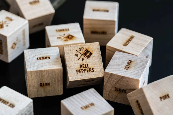 Lots of wooden cubes with writings: food, meals, food ingredients, fruits, vegetables