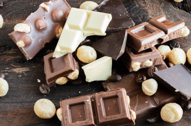 Çikolata parçaları, fındık ve kahve çekirdekleri tahtanın üzerinde.