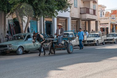 Tunus 'un eski bir kasabası. Arka planda eşek arabaları ve eski binalar var.