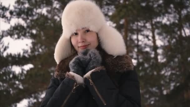 Beautiful young woman look at cam and smile, freezing trying to warm up. Closeup — 图库视频影像