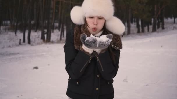 Сніг, красива жінка-модель розважається біля лісу. Молода жінка насолоджується снігом. Зимовий ліс — стокове відео