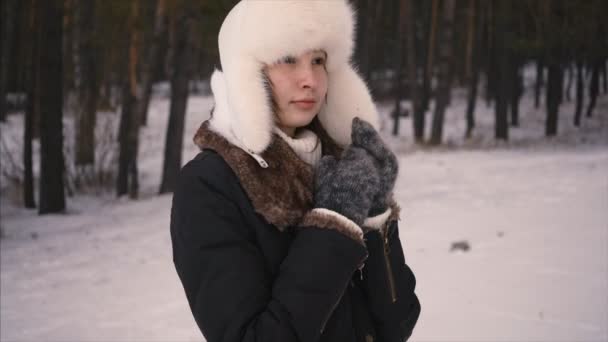 Vacker ung kvinna i vit hatt ler i vinter skog kall flicka lycklig natur vit rolig lycka modell porträtt. Närbild — Stockvideo