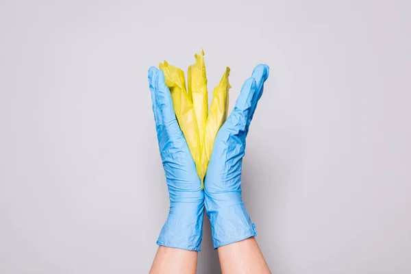 La mano femminile nei guanti domestici tiene i cuscinetti femminili — Foto Stock