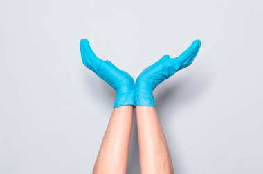 Gri arka planda mavi silikon eldiven el işareti ok gösterir.