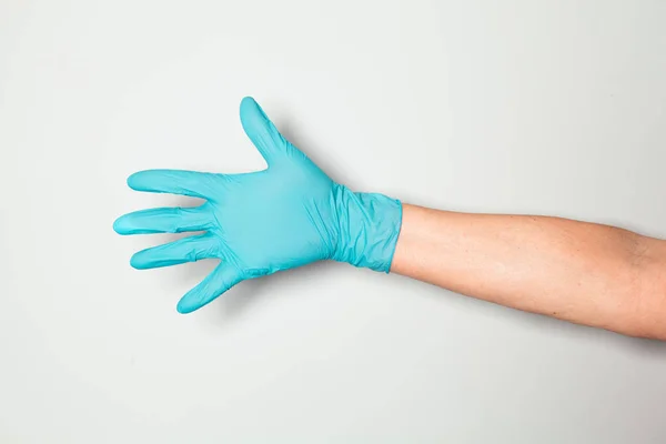Hand in blue silicone glove on grey background shows the sign OK. — Stock Photo, Image