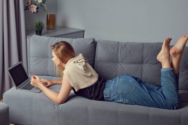 Evde çalışan serbest çalışan bir kadın. Projesini hazırlamak ve not defterine not almak için dizüstü bilgisayar kullanan bir kız. Seçici odaklanma elde..