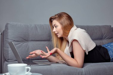 Evde çalışan serbest çalışan bir kadın. Projesini hazırlamak için dizüstü bilgisayar kullanan ve deftere not alan bir kız.