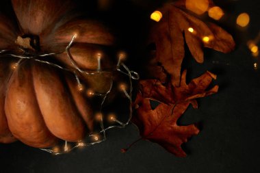 Siyah arka planlı kuru yapraklı Cadılar Bayramı kabağı