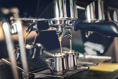 Demir kupalarda kafeteryada profesyonel bir kahve makinesinde kahve yapmak.