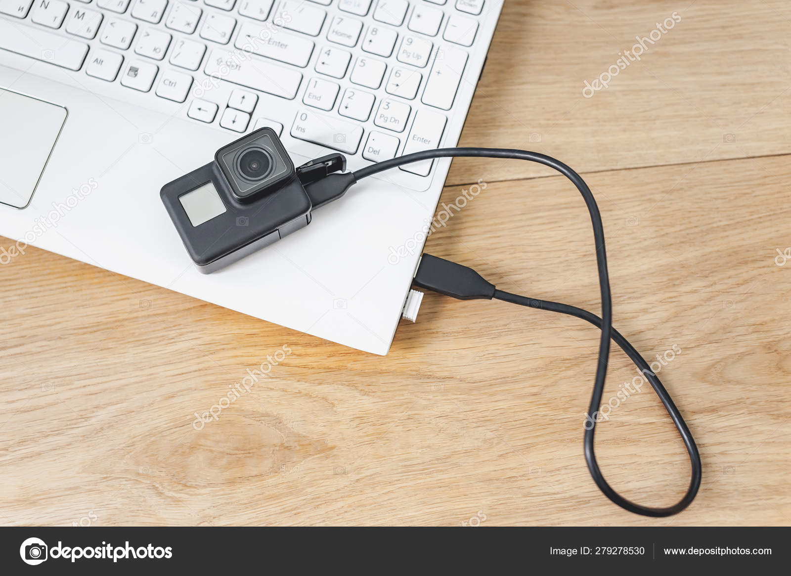 Action Camera Connected To A White Laptop Against The Background Of A Wooden Table Stock Photo Image By C Victorprilepa