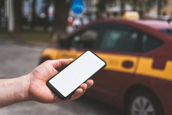 Mock up de um smartphone na mão, no fundo de um carro de táxi . — Fotografia de Stock