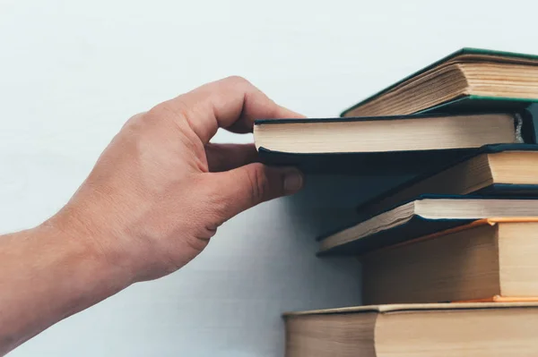 Hand húz egy könyvet, a könyvespolc. — Stock Fotó