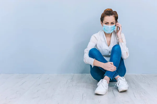 Meisje Met Een Medisch Masker Spreekt Aan Telefoon Zittend Vloer — Stockfoto