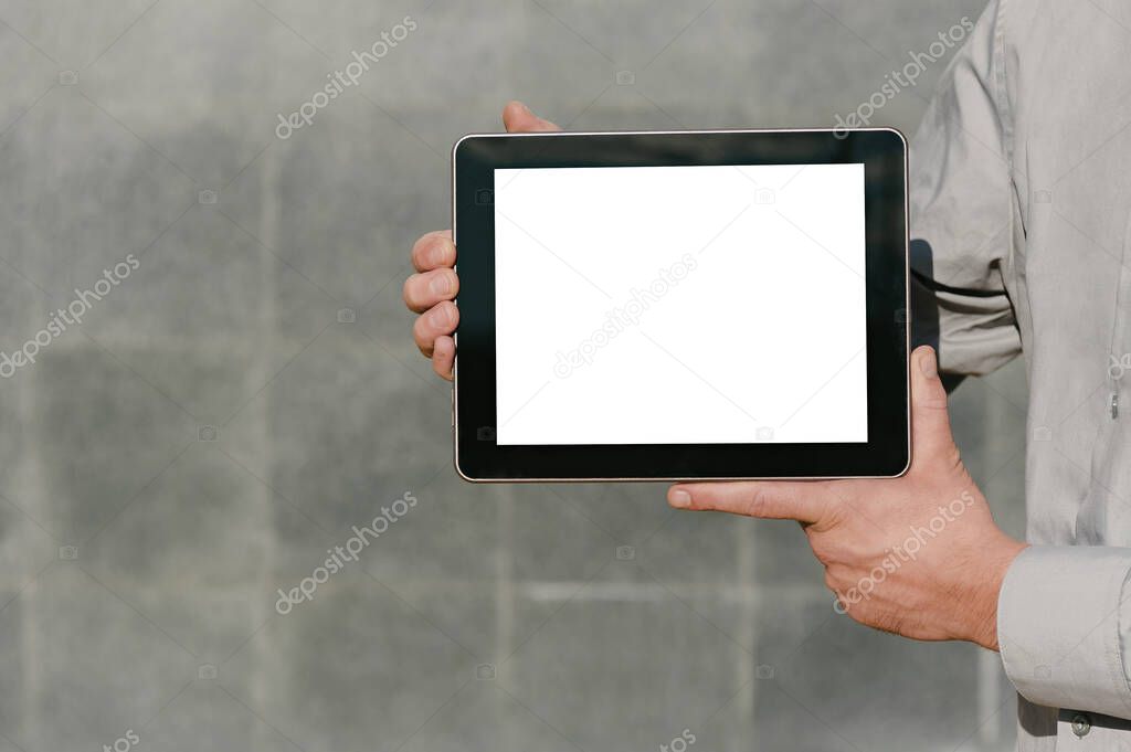 Close up, Mock up tablet, presentation of business plan, man hands. against the background of a concrete wall
