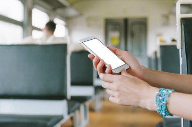 Akıllı telefon taklidi yap, kadın eline yakın çekim yap. Bir tren vagonunun arka planında
