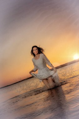 Genç bayan gün batımında suda