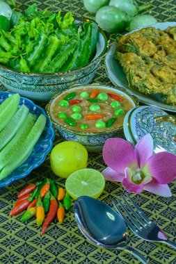 Nam Prik Kapi (Baharatlı karides hamur) eski zamanlarda, taze sebze, beyazlatılmış sebze ve yumurtalı kızarmış sebze sos olarak kullanılmış, Eaten inanılmaz derecede lezzetli bir garnitür olarak devralınan bir geleneksel Tayland yemeğidir.