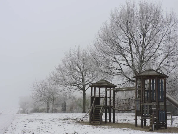 Playground with white frost. Dew frosted on the wood during a cold weekend.