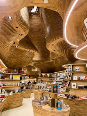 Wooden, dynamic and organic ceiling of the National Museum shop. April 2019, Doha. clipart