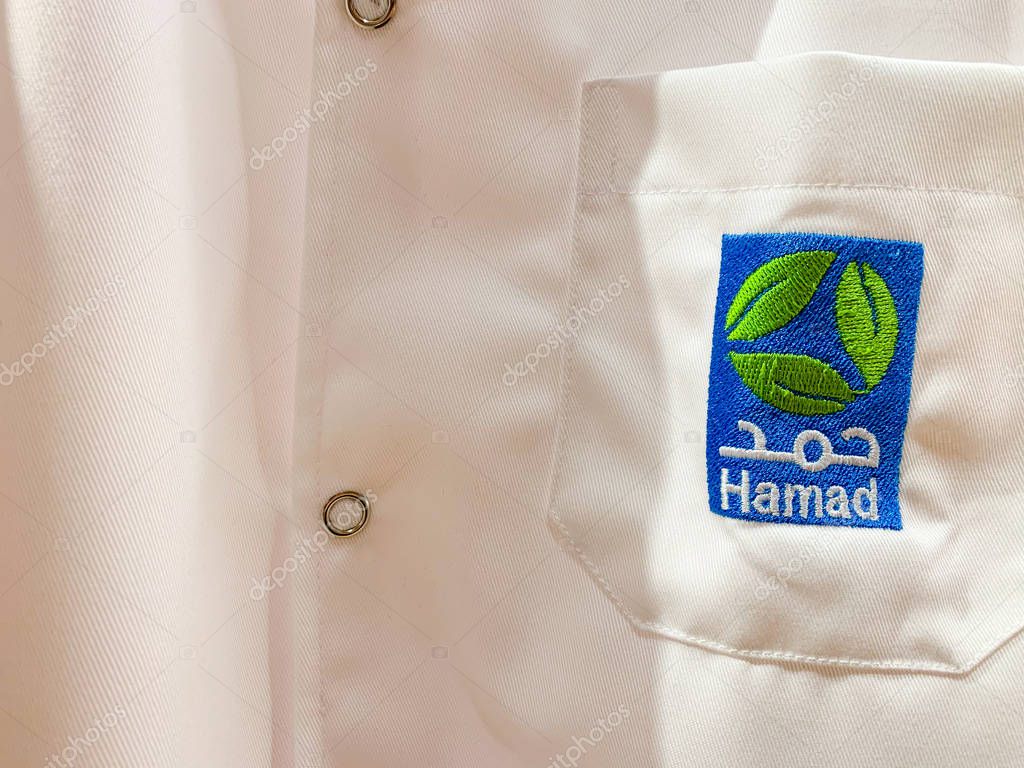 White workwear of a doctor or assistant with Hamad logo in Arabic and English. Hamad (HMC) is the biggest medical provider. April 2019, Doha/ Qatar.