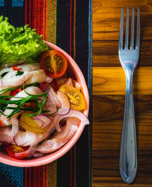 Renkli bir masa örtüsü üzerinde bir tabak ceviche manzarası