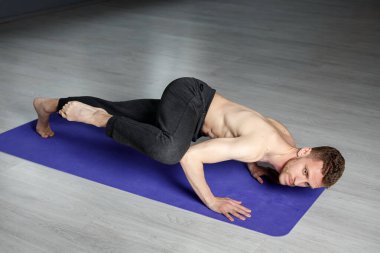 Genç adam dizinden vurarak şınav çekiyor..