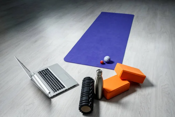Spor malzemeleri ve evde esneme ve yoga için dizüstü bilgisayar.