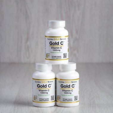 Kamyanets-Podilskyi, Ukrayna - 27 Haziran 2020: Kamyanets-Podilskyi, Ukrayna - 27 Haziran 2020: California Gold Nutrition, Gold C, C vitamini, 1000 mg. Hafif ahşap arka planda hapları olan şişeler..