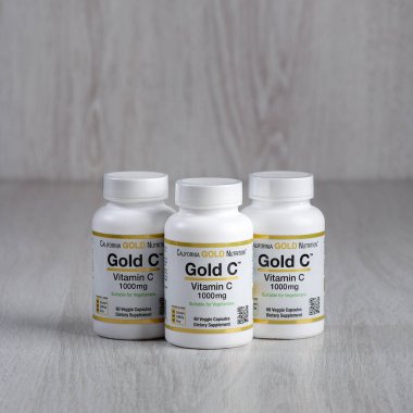 Kamyanets-Podilskyi, Ukrayna - 27 Haziran 2020: Kamyanets-Podilskyi, Ukrayna - 27 Haziran 2020: California Gold Nutrition, Gold C, C vitamini, 1000 mg. Hafif ahşap arka planda hapları olan şişeler..
