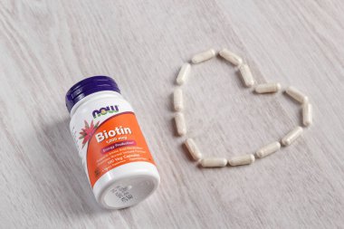 Kamyanets-Podilskyi, Ukrayna - Kasım 04, 2019: Now Foods, Biotin, 1,000 mcg, 100 Veg Capsules. Hafif ahşap arka planda haplarla dolu bir şişe.