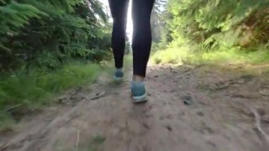 Genç kız dağlarda orman yolunda yürüyor. Dağ ormanlarında yürüyüş..