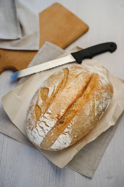 Taze pişmiş tartin ekmek ve tahtanın üzerinde bir bıçak..