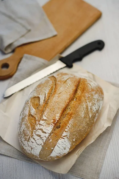 Taze pişmiş tartin ekmek ve tahtanın üzerinde bir bıçak.. 