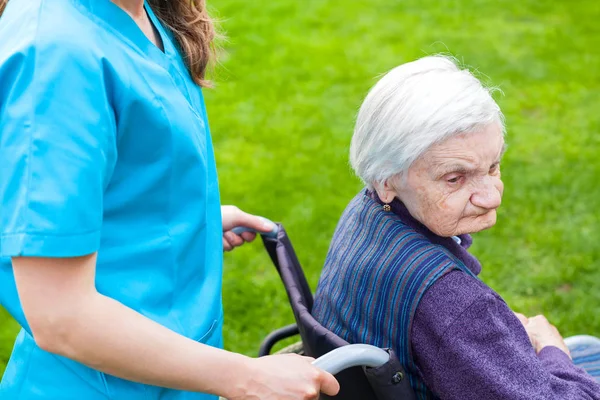 Старшая Женщина Инвалид Инвалидной Коляске Гуляет Свежем Воздухе Женщиной Смотрителем — стоковое фото