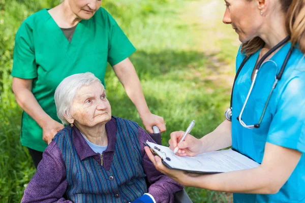 Kranke Ältere Frau Rollstuhl Krankenschwestern Diskutieren Behandlung Freien — Stockfoto