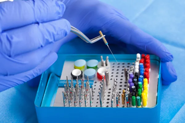 Renkli steril Endodontik dosyaları ve dişçi eller mavi eldivenler
