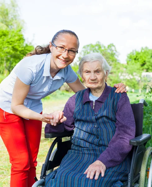 Handicapped Elderly Woman Sitting Wheelchair Smiling Caretaker Outdoor — Stock Photo, Image