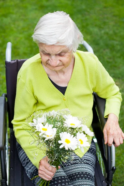 Behinderte Ältere Frau Sitzt Rollstuhl Und Erhält Einen Blumenstrauß Zum — Stockfoto