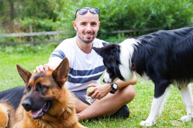 Onun iki köpek ile oynarken mutlu bir adam fotoğrafı